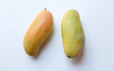 İştah açıcı sarı mango Mahachanok Mango (Mangifera indica L) hasır sepetin içinde beyaz arka planda izole edilmiş yapraklar. Tayland 'ın sağlıklı meyvesi. Yaz meyvesi.