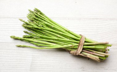 Taze yeşil çiğ sebzeli kuşkonmaz (kuşkonmaz resmi) ahşap arka planda izole edilir. Vejetaryen sağlıklı yiyecek. Sağlıklı beslenme için sebze.