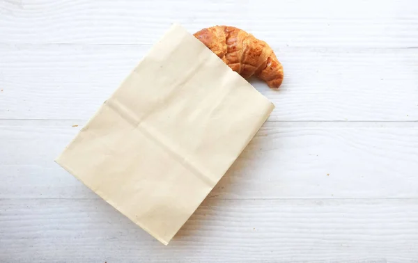新鲜烘焙的金黄色羊角面包或法国羊角面包 白色背景的木制桌子 顶部的视野和平坦的层次结构 健康的饮食和甜食概念 法国早餐 — 图库照片