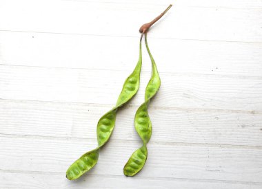 Acı fasulye, bükülmüş fasulye, kokuşmuş fasulye, sato, petai ya da pakria (parkia speciosa), ahşap bir masada yemek pişirmeye hazırlan. Tayland ve Asya 'nın malzemeleri için bitkiler 