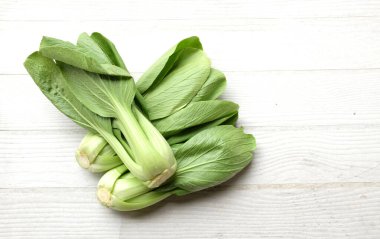 taze ve lezzetli yeşil yapraklar Bok choy, Çin lahanası, kanton marulu, küçük choy sum, yeşil pak choi, pak choi, (brassica chinensis var. Beyaz bir ahşap üzerinde çingeneler.