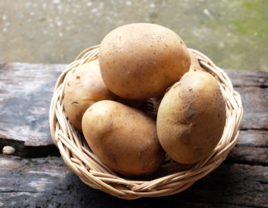 Bir sepet dolusu taze çiğ patates (Solanum tuberosum) kafası ya da tahtadan bir sepet içinde taze patates.