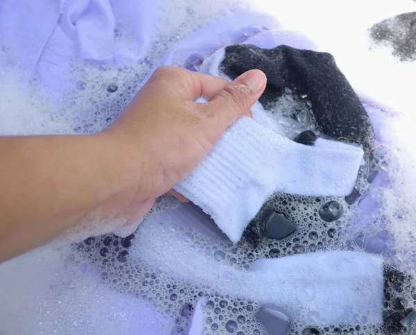 Hand of Asian housewife washing white clothes ,socks, school socks,school uniform,Student uniforms with bubble detergent in basin.Laundry concept