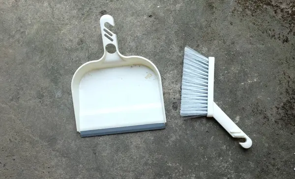set of plastic hand brooms, dustpan on acement floor  .health care and cleaning home ,cleaning, service, hygiene concept