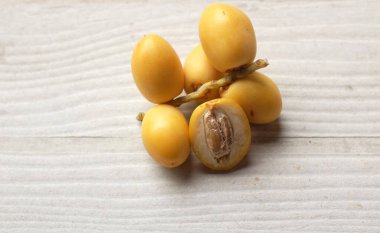 Taze palmiye anka kuşu dactylifera veya beyaz ahşap zemin üzerinde hurma meyvesi bir grup iştah açıcı yatar 