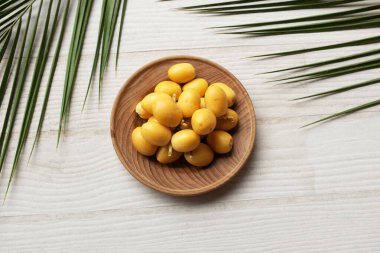 Taze palmiye anka kuşu dactylifera meyvesi ya da ahşap bir arka planda bir tabakta hurma meyvesi. 