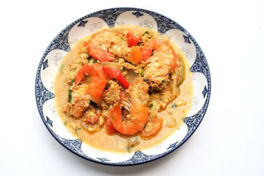 Üst ve düz tabakta kızarmış sarı körili karides var. Köri tozu ile karıştırılmış karides. Lezzetli sarı yemek. Bu menü iştah açıcı ve sağlıklı ve yararlı görünüyor. Tayland 'ın ünlü yemekleri.