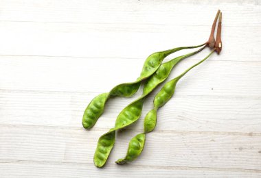 Acı fasulye, bükülmüş fasulye, kokulu fasulye, sato, petai ya da pakria, (parkia speciosa) ahşap bir sırt damlasında pişirmeye hazırlan. Tayland ve Asya 'ya ait besinler için bitkiler. 