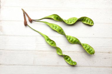 Acı fasulye, bükülmüş fasulye, kokulu fasulye, sato, petai ya da pakria, (parkia speciosa) ahşap bir sırt damlasında pişirmeye hazırlan. Tayland ve Asya 'ya ait besinler için bitkiler. 