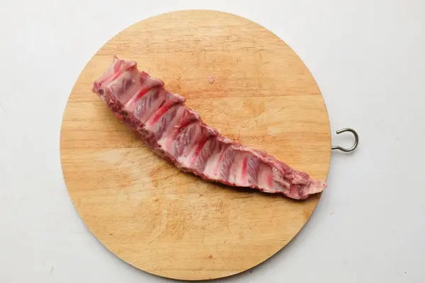 新鮮な生の豚の肋骨のヒープは 骨のロー肉 木製の切断板の生の豚骨を白い背景に隔離しました 広告のための料理コンセプトと食品コンセプト — ストック写真