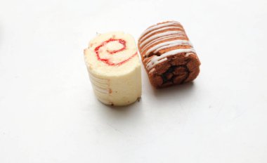 Çikolatalı, vanilyalı ve çilekli Süngerli kek rulosu, beyaz arka planda izole edilmiş tabakta.