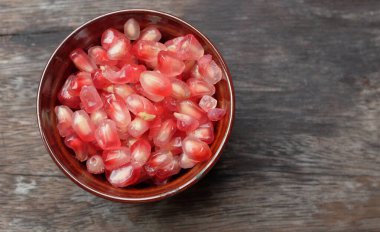 Taze taze sulu nar taneleri, (Punica granatum) tohumları tahtadan siyah masanın üzerinde.