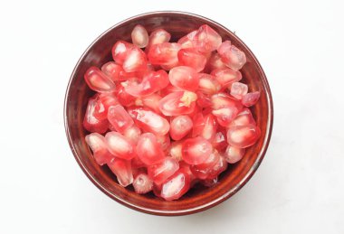 Taze taze sulu nar taneleri, (Punica granatum) tohumları kasede beyaz bir zemin üzerinde