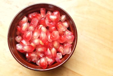 Tahta masadaki kasedeki taze sulu nar tohumları (Punica granatum).