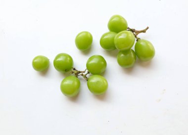 Beyaz arka fonda izole edilmiş taze tatlı yeşil Muscat (Vitis vinifera) üzüm ve yaprağı. Japon üzümleri. Üzüm yeşili. Tadı tatlı ve doğal.