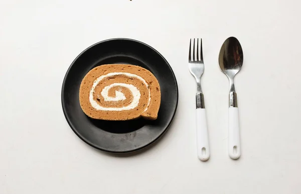Appetizing a coffee roll cake,Sponge cake roll , Swiss roll stuffed dessert arranged in plates isolated on white backdrop