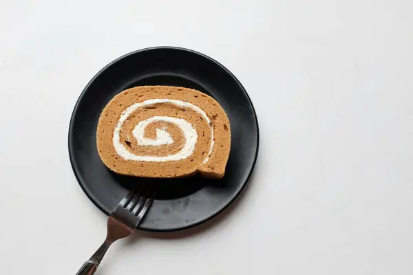 Appetizing a coffee roll cake,Sponge cake roll , Swiss roll stuffed dessert arranged in plates isolated on white backdrop