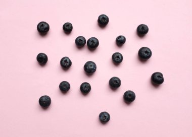 Düz kompozisyonda pembe pastel arka planda taze sulu böğürtlenler vardı. Sağlıklı yeme kavramı. Organik gıda, antioksidan, vitamin, mavi gıda. Yabanmersini desenli. Berrie taze.