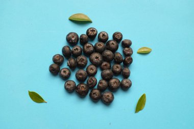 Mavi arka planda lezzetli taze sulu böğürtlenli düz kompozisyon. Sağlıklı yeme kavramı. Organik gıda, antioksidan, vitamin, mavi gıda. Yabanmersini desenli. Berrie taze.