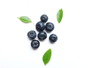 Düz kompozisyonda beyaz bir zeminde lezzetli taze, sulu böğürtlenler vardı. Sağlıklı yeme kavramı. Organik gıda, antioksidan, vitamin, mavi gıda. Yabanmersini desenli. Berrie taze.