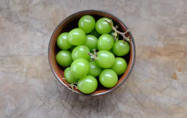 yeşil parlak muscat üzümü kabın içinde, ahşap bir arka planda izole edilmiş.