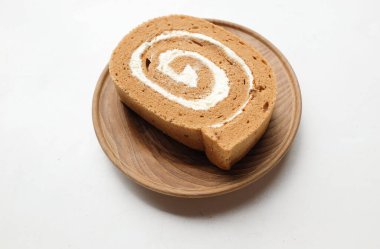 İştah açıcı bir kahveli kek, İsviçre usulü kek, İsviçre usulü kek, jöleli kek, ruloda kek veya kahve aromalı sünger rulosu, kahve molası için yuvarlak kahverengi tabakta servis edilir.