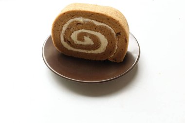 İştah açıcı bir kahveli kek, İsviçre usulü kek, İsviçre usulü kek, jöleli kek, ruloda kek veya kahve aromalı sünger rulosu, kahve molası için yuvarlak kahverengi tabakta servis edilir.