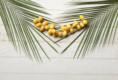 Palmiye anka kuşu dactylifera 'nın üst ve düz grup meyveleri veya yeşil yapraklı hurma meyveleri beyaz zemin üzerinde izole