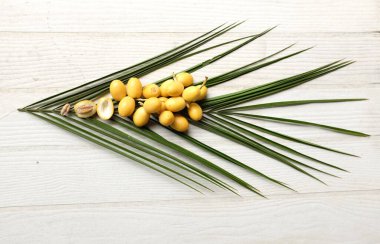 Palmiye anka kuşu dactylifera 'nın üst ve düz grup meyveleri veya yeşil yapraklı hurma meyveleri beyaz zemin üzerinde izole