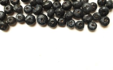 Üst ve düz bir zemin üzerinde taze organik sulu yaban mersinleri, olgun tatlı yaban mersinli izolasyon beyaz zemin üzerinde uzanıyor. Yabanmersini arka planı. Metnin için kopyalama alanı ile. Vejetaryen ve vejetaryen. Sağlıklı meyve, konsept antioksidan., 