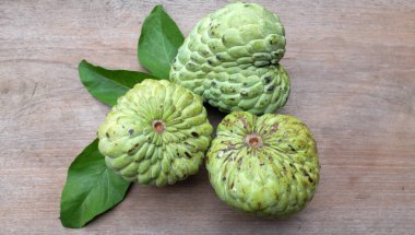 Taze yeşil kremalı elma, elma şekeri, arkaplanda yaprak olan Annona squamosa l.) meyveler. Tropikal egzotik meyve ve sağlıklı meyve, diyet ve vejetaryen beslenme