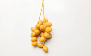 Palmiye anka kuşu dactylifera bir demet sarı meyve veya beyaz arka planda izole hurma meyvesi. Sağlıklı yiyecek, geleneksel, lezzetli ve sağlıklı ramazan.