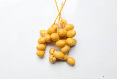 Palmiye anka kuşu dactylifera bir demet sarı meyve veya beyaz arka planda izole hurma meyvesi. Sağlıklı yiyecek, geleneksel, lezzetli ve sağlıklı ramazan.