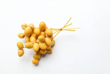 Palmiye anka kuşu dactylifera bir demet sarı meyve veya beyaz arka planda izole hurma meyvesi. Sağlıklı yiyecek, geleneksel, lezzetli ve sağlıklı ramazan.