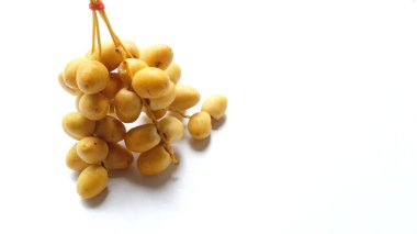 Palmiye anka kuşu dactylifera bir demet sarı meyve veya beyaz arka planda izole hurma meyvesi. Sağlıklı yiyecek, geleneksel, lezzetli ve sağlıklı ramazan.