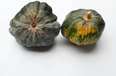 Bir yığın taze çiğ Japon balkabağı (Cucurbita moschata), Kabocha kabağı, beyaz bir arka planda izole edilmiş. Sağlıklı gıda sebze, meyve ve gıda ticareti fikri