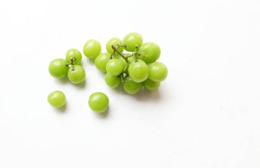 Bir demet taze tatlı yeşil muscat (Vitis vinifera) üzümü, beyaz bir arkaplanda izole edilmiş yapraklarla. Yeşil üzümler. Japon üzümleri. Üzüm yeşili. Tadı tatlı ve doğal..