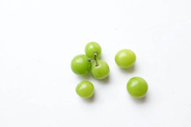 Bir demet taze tatlı yeşil muscat (Vitis vinifera) üzümü, beyaz bir arkaplanda izole edilmiş yapraklarla. Yeşil üzümler. Japon üzümleri. Üzüm yeşili. Tadı tatlı ve doğal..