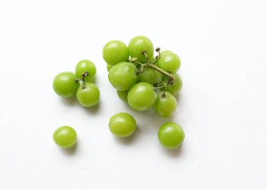 Bir demet taze tatlı yeşil muscat (Vitis vinifera) üzümü, beyaz bir arkaplanda izole edilmiş yapraklarla. Yeşil üzümler. Japon üzümleri. Üzüm yeşili. Tadı tatlı ve doğal..