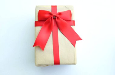 Kırmızı saten kurdeleli el işi kağıt hediye kutusunun kuş bakışı görüntüsü. Beyaz arkaplanda kopyalama alanı ile izole edilmiş..
