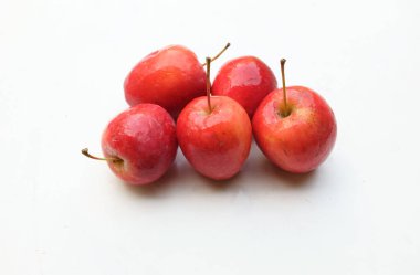 Taze organik olgun kırmızı cüce elma, prenses elması, mini elma, küçük elma, kiraz elması, beyaz arka planda izole edilmiş parlak kırmızı elmalar. Sağlıklı meyve kavramı.