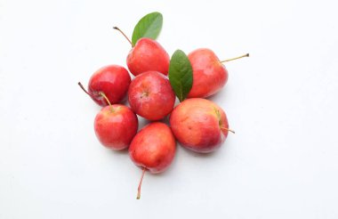 Taze organik olgun kırmızı cüce elma, prenses elması, mini elma, küçük elma, kiraz elması, yeşil yapraklı parlak kırmızı elmalar beyaz arka planda izole edilmiş. Sağlıklı meyve kavramı.