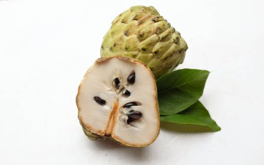 Taze yeşil kremalı elma, elma şekeri, anona cherimola (annona squamosa l.) beyaz arka planda yalıtılmış yapraklarla ikiye bölünmüş meyve. Tropikal egzotik meyve ve sağlıklı meyve
