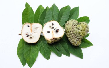 Taze yeşil kremalı elma, elma şekeri, anona cherimola (annona squamosa l.) beyaz arka planda yalıtılmış yapraklarla ikiye bölünmüş meyve. Tropikal egzotik meyve ve sağlıklı meyve