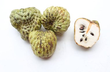 Taze yeşil kremalı elma, elma şekeri, anona cherimola (annona squamosa l.) beyaz arka planda yalıtılmış yapraklarla ikiye bölünmüş meyve. Tropikal egzotik meyve ve sağlıklı meyve