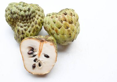 Taze yeşil kremalı elma, elma şekeri, anona cherimola (annona squamosa l.) beyaz arka planda yalıtılmış yapraklarla ikiye bölünmüş meyve. Tropikal egzotik meyve ve sağlıklı meyve