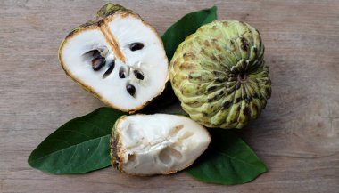 taze çiğ krema, elma şekeri, annona cherimola (annona squamosa l..) meyve, tahtadan bir masa üzerinde yalıtılmış, tropik egzotik meyve ve sağlıklı meyvelerle dilimlenmiş.