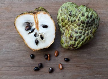 taze çiğ krema, elma şekeri, annona cherimola (annona squamosa l..) meyve, tahtadan bir masa üzerinde yalıtılmış, tropik egzotik meyve ve sağlıklı meyvelerle dilimlenmiş.