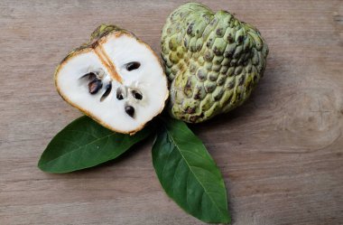 taze çiğ krema, elma şekeri, annona cherimola (annona squamosa l..) meyve, tahtadan bir masa üzerinde yalıtılmış, tropik egzotik meyve ve sağlıklı meyvelerle dilimlenmiş.