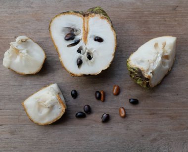 taze çiğ krema, elma şekeri, annona cherimola (annona squamosa l..) meyve, tahtadan bir masa üzerinde yalıtılmış, tropik egzotik meyve ve sağlıklı meyvelerle dilimlenmiş.